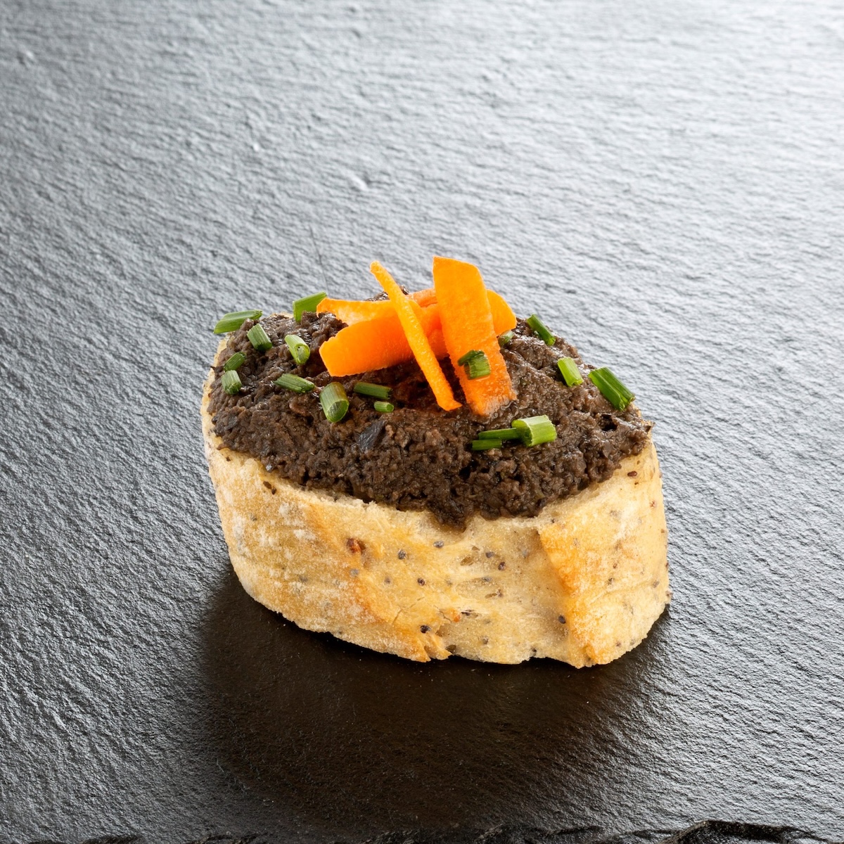 Canapé mit Tapenade, garniert mit Möhren und Schnittlauch – eine Catering-Spezialität für Firmenveranstaltungen in München